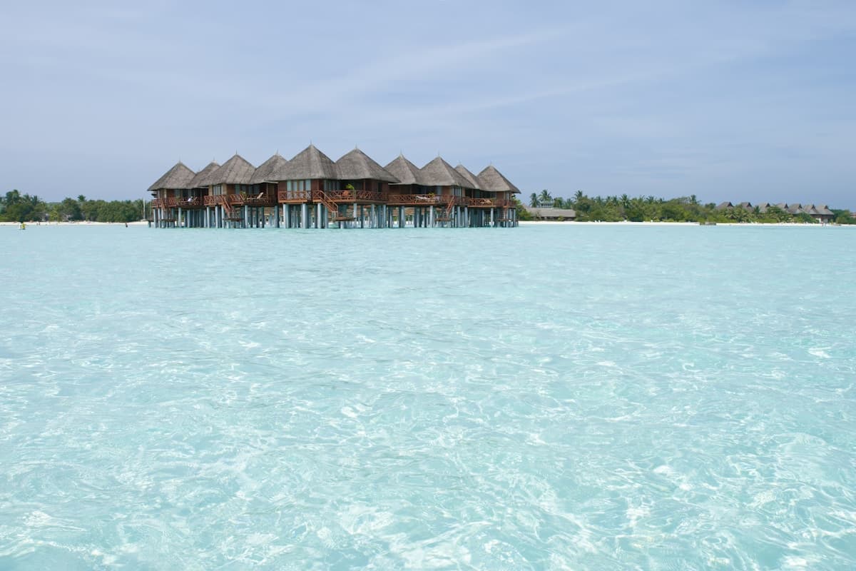 Rustic wooden Pelican Bar standing on stilts in turquoise Caribbean waters